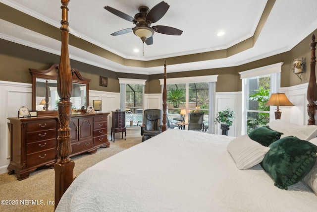 carpeted bedroom featuring a raised ceiling, ornamental molding, and ceiling fan