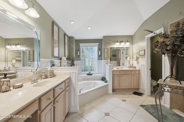 bathroom with lofted ceiling, tile patterned floors, toilet, vanity, and a bathtub