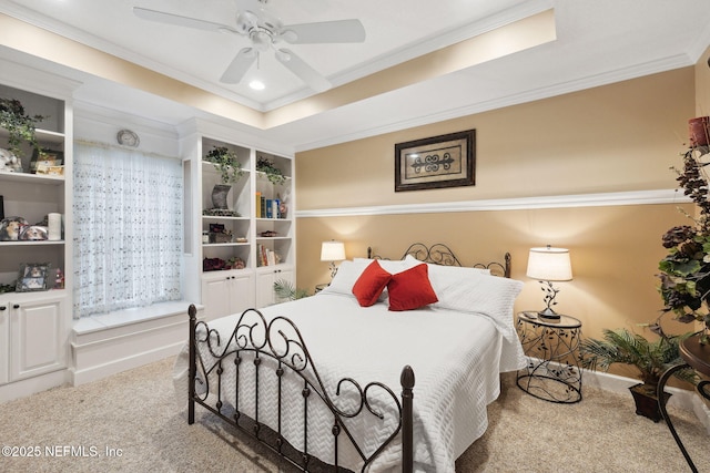 bedroom with crown molding, a tray ceiling, light colored carpet, and ceiling fan