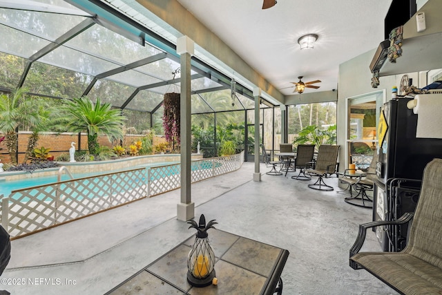 view of pool with a patio, ceiling fan, and glass enclosure