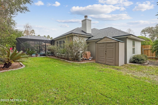 back of house featuring a storage shed, a yard, and glass enclosure