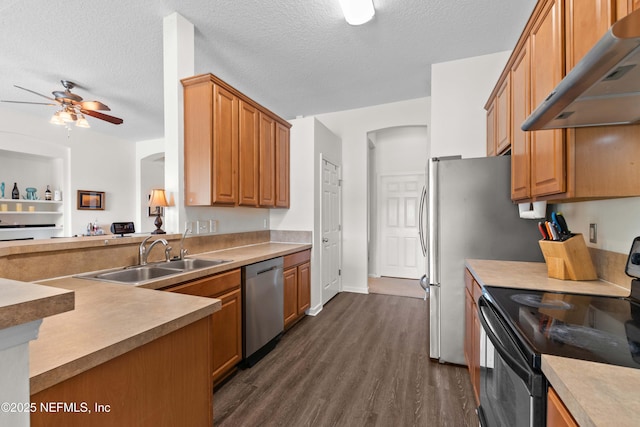 kitchen featuring stainless steel appliances, a sink, light countertops, and under cabinet range hood