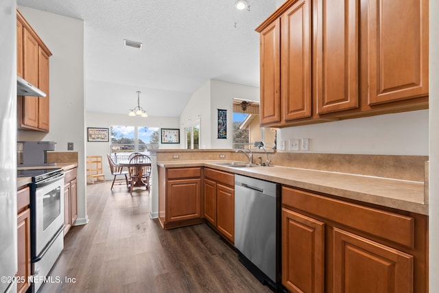 kitchen featuring stainless steel appliances, light countertops, visible vents, brown cabinetry, and a sink