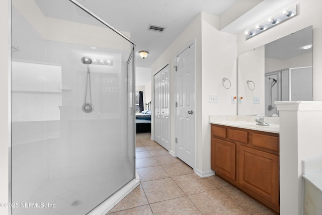 full bath featuring visible vents, a stall shower, connected bathroom, vanity, and tile patterned flooring