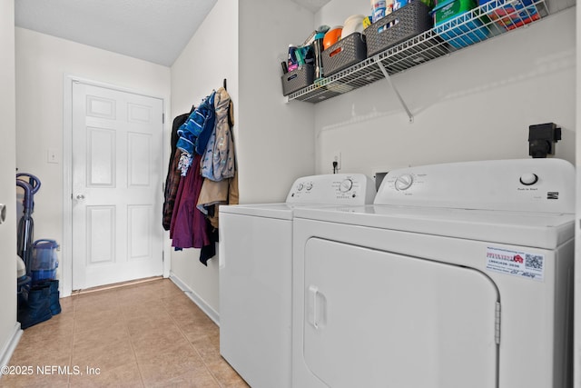 clothes washing area with laundry area, light tile patterned floors, and washer and dryer