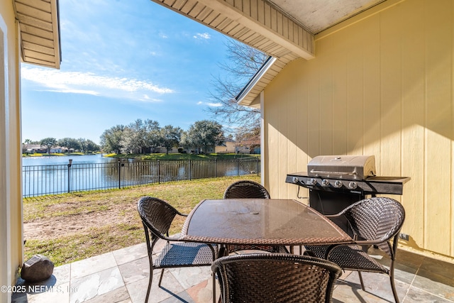 view of patio featuring a water view, a fenced backyard, a grill, and outdoor dining area