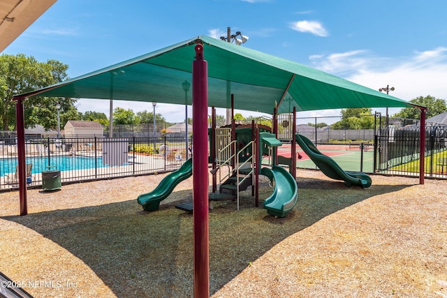 community play area featuring a community pool and fence