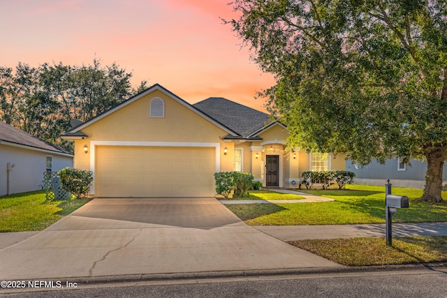 ranch-style house featuring driveway, an attached garage, a lawn, and stucco siding