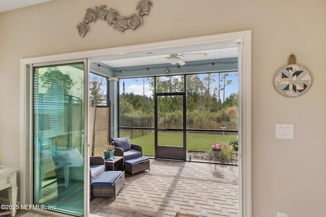 sunroom / solarium featuring a ceiling fan