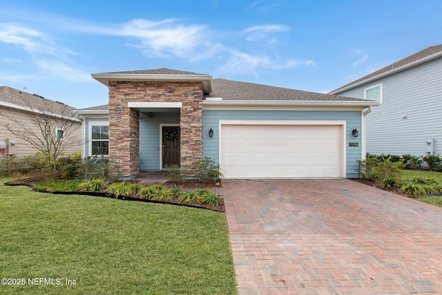 prairie-style home with a garage, stone siding, decorative driveway, and a front yard