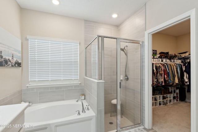 full bath with a shower stall, a walk in closet, a bath, and recessed lighting