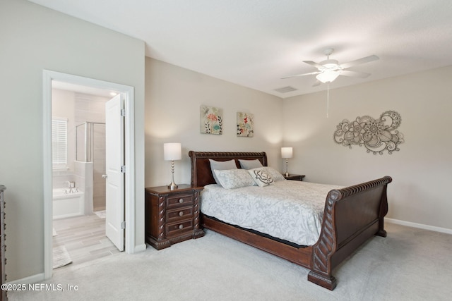 bedroom with light carpet, connected bathroom, baseboards, and ceiling fan