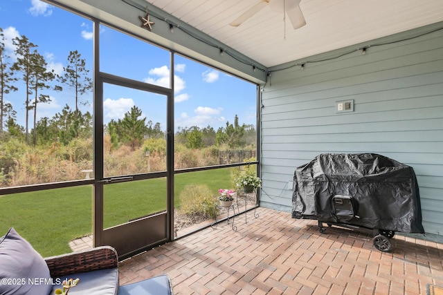 sunroom / solarium featuring a ceiling fan