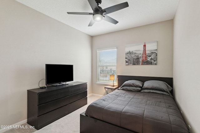 bedroom with a ceiling fan, light colored carpet, and baseboards