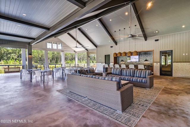 interior space featuring ceiling fan, high vaulted ceiling, concrete flooring, and beamed ceiling