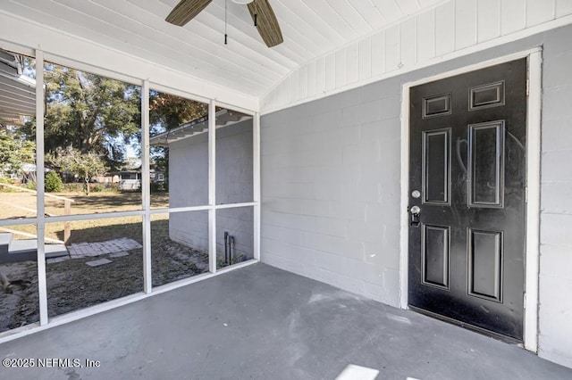 unfurnished sunroom with ceiling fan and vaulted ceiling