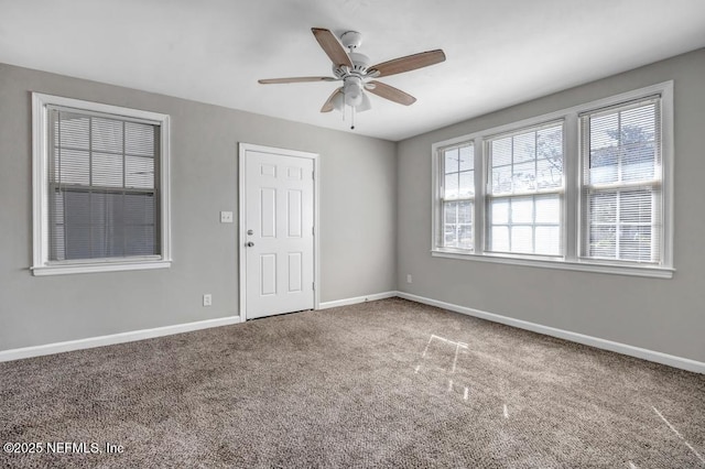 carpeted spare room featuring ceiling fan