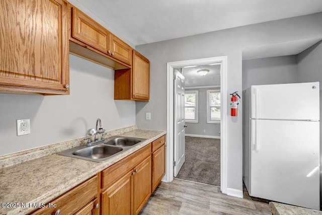 kitchen with white refrigerator, light hardwood / wood-style flooring, and sink