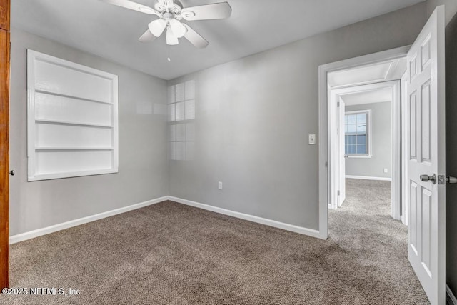 carpeted spare room featuring built in features and ceiling fan