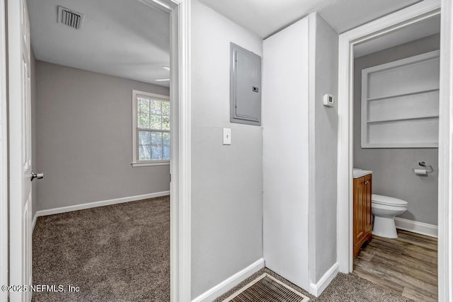 bathroom with built in shelves, electric panel, vanity, and toilet