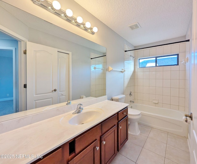 full bathroom with tile patterned floors, a textured ceiling, toilet, vanity, and tiled shower / bath