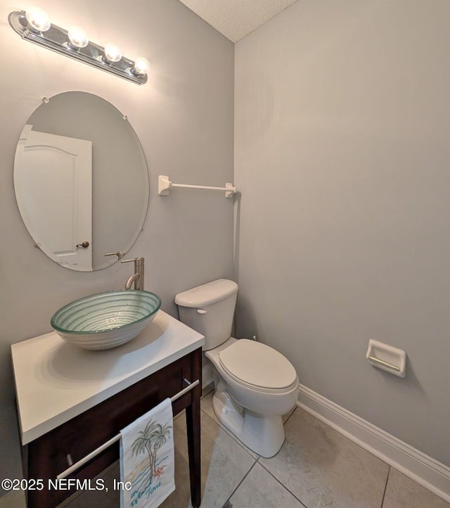 bathroom with vanity, a textured ceiling, tile patterned floors, and toilet