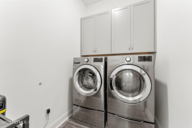 washroom with washer and dryer and cabinets