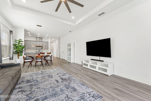 living room with light wood-type flooring and ceiling fan