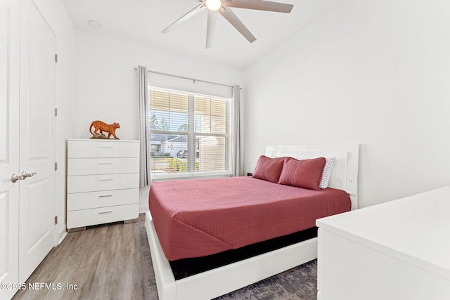 bedroom with a closet, ceiling fan, hardwood / wood-style floors, and lofted ceiling