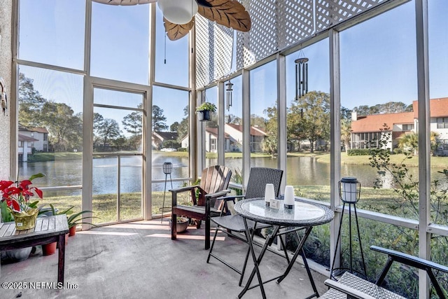 sunroom / solarium featuring a water view and ceiling fan