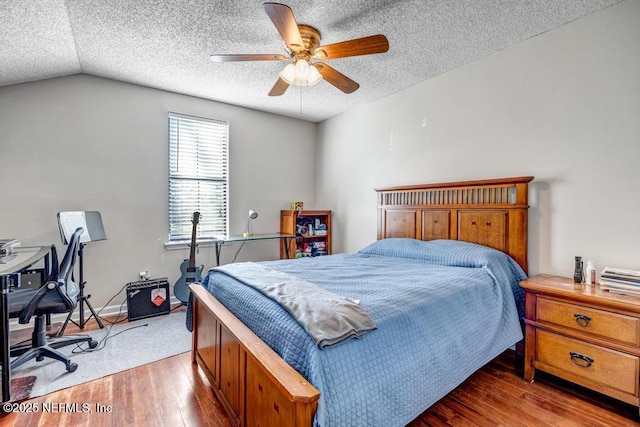 bedroom with light hardwood / wood-style flooring, vaulted ceiling, and ceiling fan