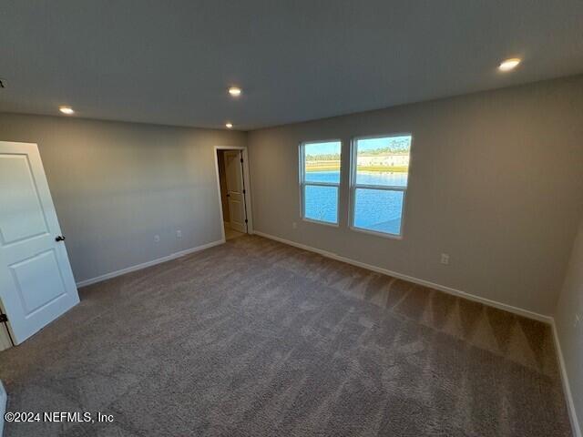 unfurnished room featuring dark colored carpet