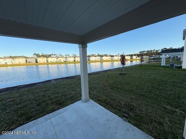 view of yard with a patio area, a water view, and central AC unit