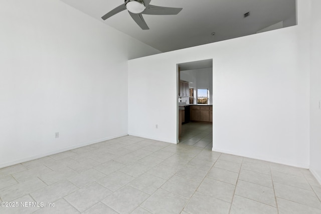 tiled spare room with ceiling fan and vaulted ceiling