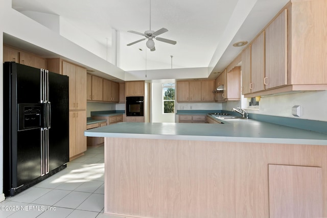 kitchen featuring kitchen peninsula, light brown cabinetry, light tile patterned floors, and black appliances