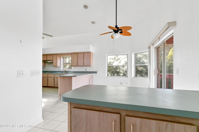 kitchen featuring kitchen peninsula, light tile patterned floors, ceiling fan, and sink