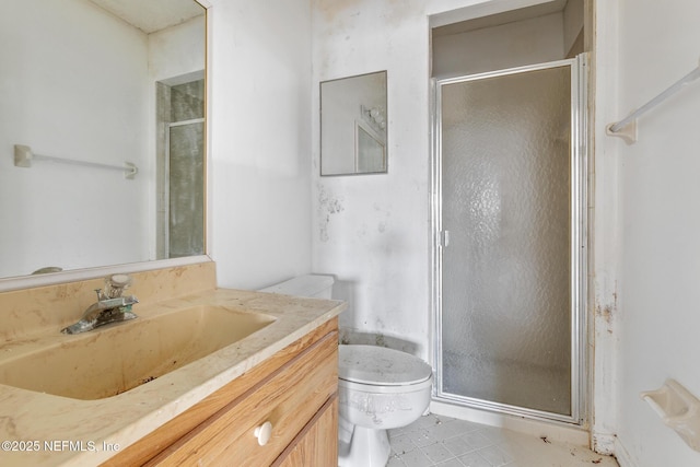 bathroom with vanity, toilet, and a shower with door