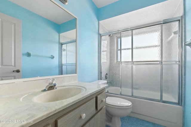 full bathroom featuring combined bath / shower with glass door, tile patterned floors, vanity, and toilet