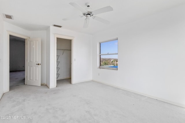 unfurnished bedroom featuring ceiling fan, a closet, and light carpet