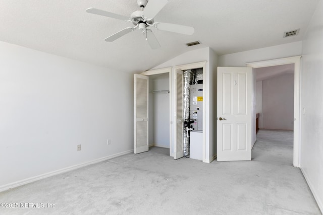 unfurnished bedroom with ceiling fan, light colored carpet, and vaulted ceiling