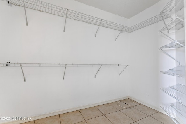 walk in closet with light tile patterned floors