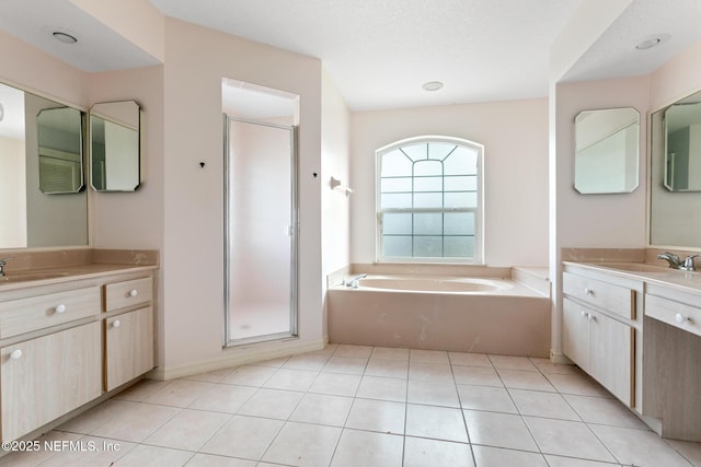 bathroom with tile patterned floors, vanity, a textured ceiling, and plus walk in shower