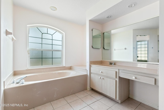 bathroom featuring tile patterned flooring, vanity, and a bathtub