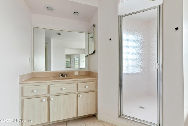 bathroom featuring tile patterned floors, vanity, and a shower with shower door