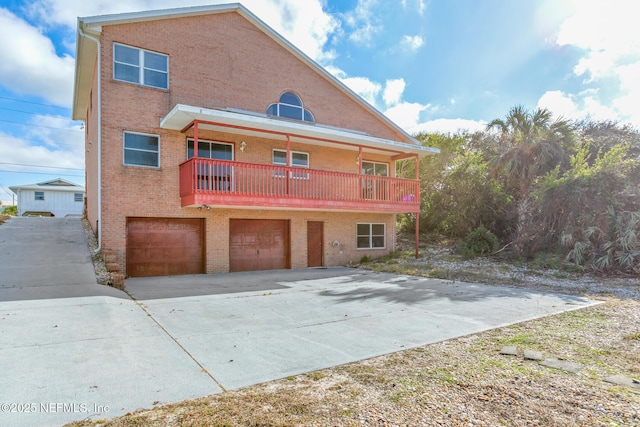 back of house featuring a balcony and a garage