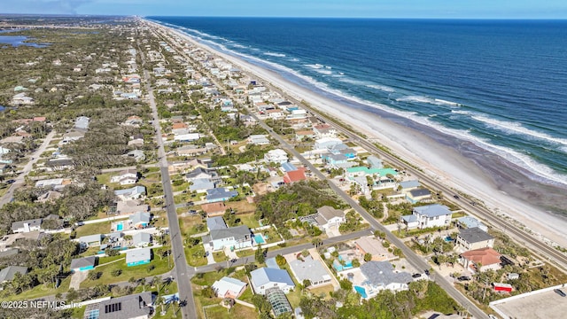 drone / aerial view featuring a beach view and a water view