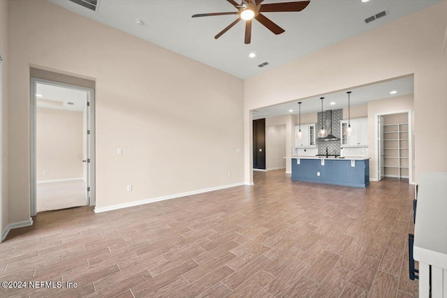 unfurnished living room with ceiling fan