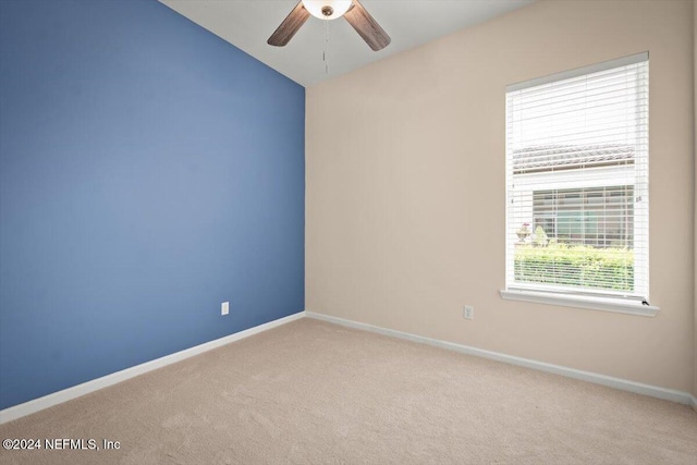 carpeted spare room featuring ceiling fan and vaulted ceiling