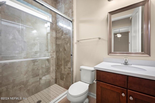 bathroom with vanity, ceiling fan, toilet, and a shower with door