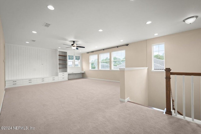 unfurnished living room featuring light carpet and ceiling fan